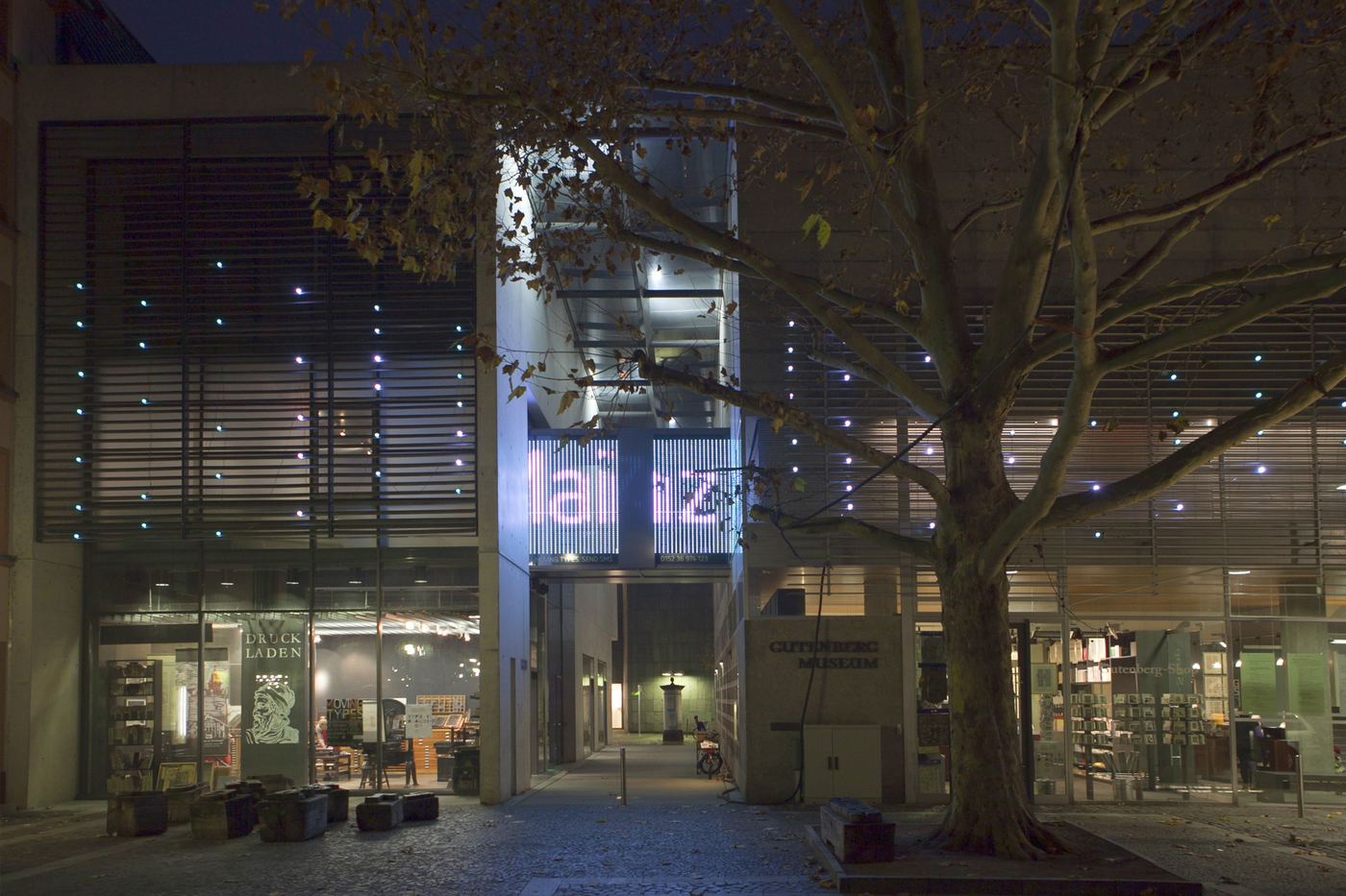The museum square at night, the word Mainz in white on the bridge
