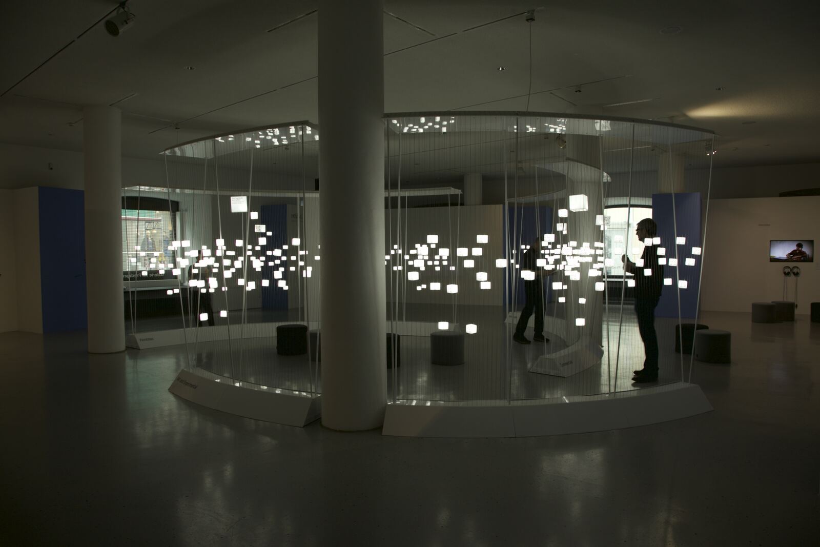 The curved cube field in the white exhibition hall of the Galerie im Prediger, with two visitors