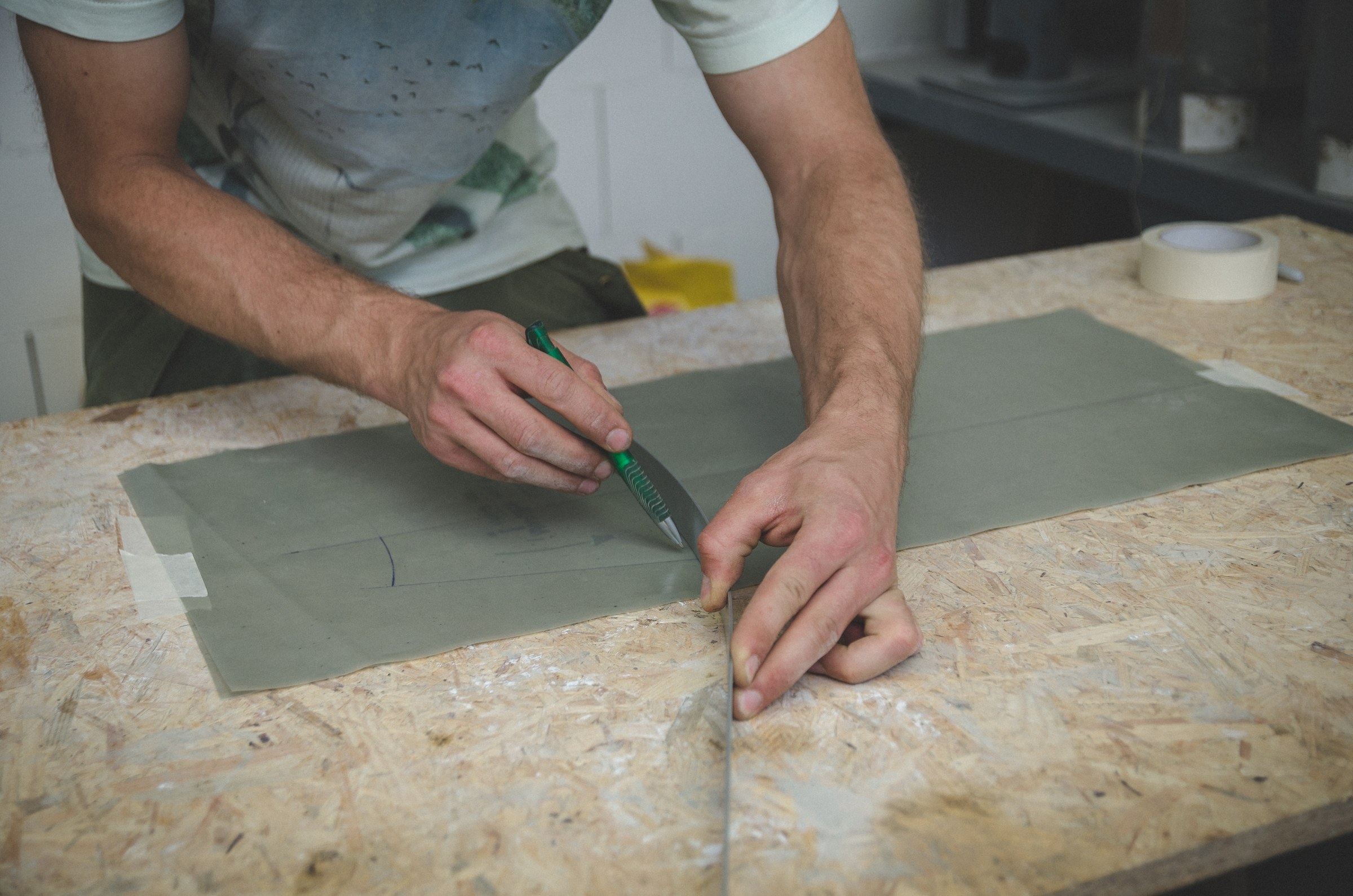 A maker marking material at a workbench
