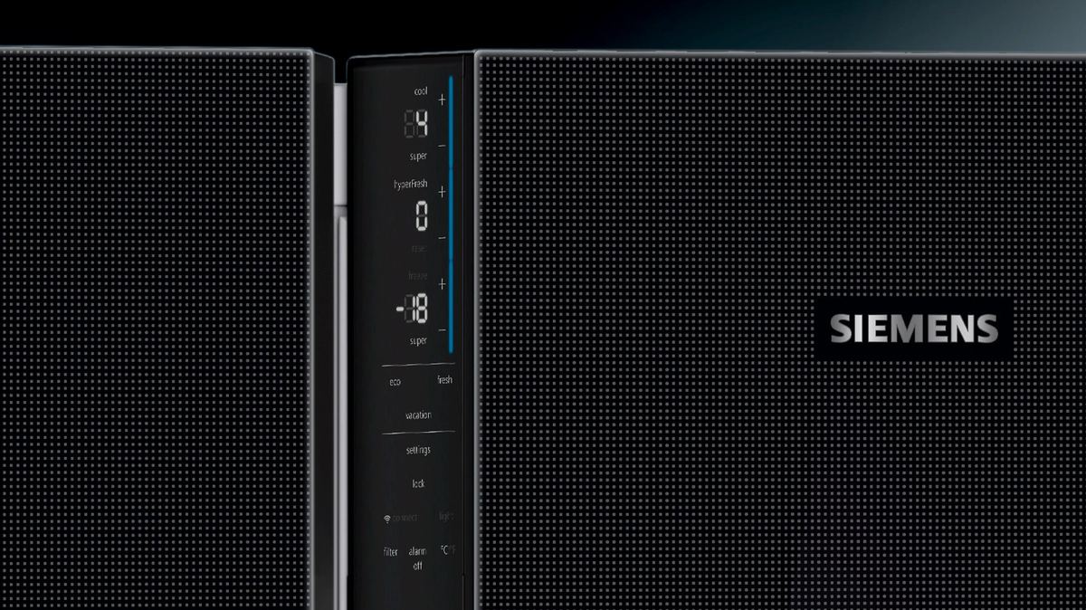 Close-up of a dark refrigerator door with a narrow vertical display showing temperatures, next to the Siemens logo