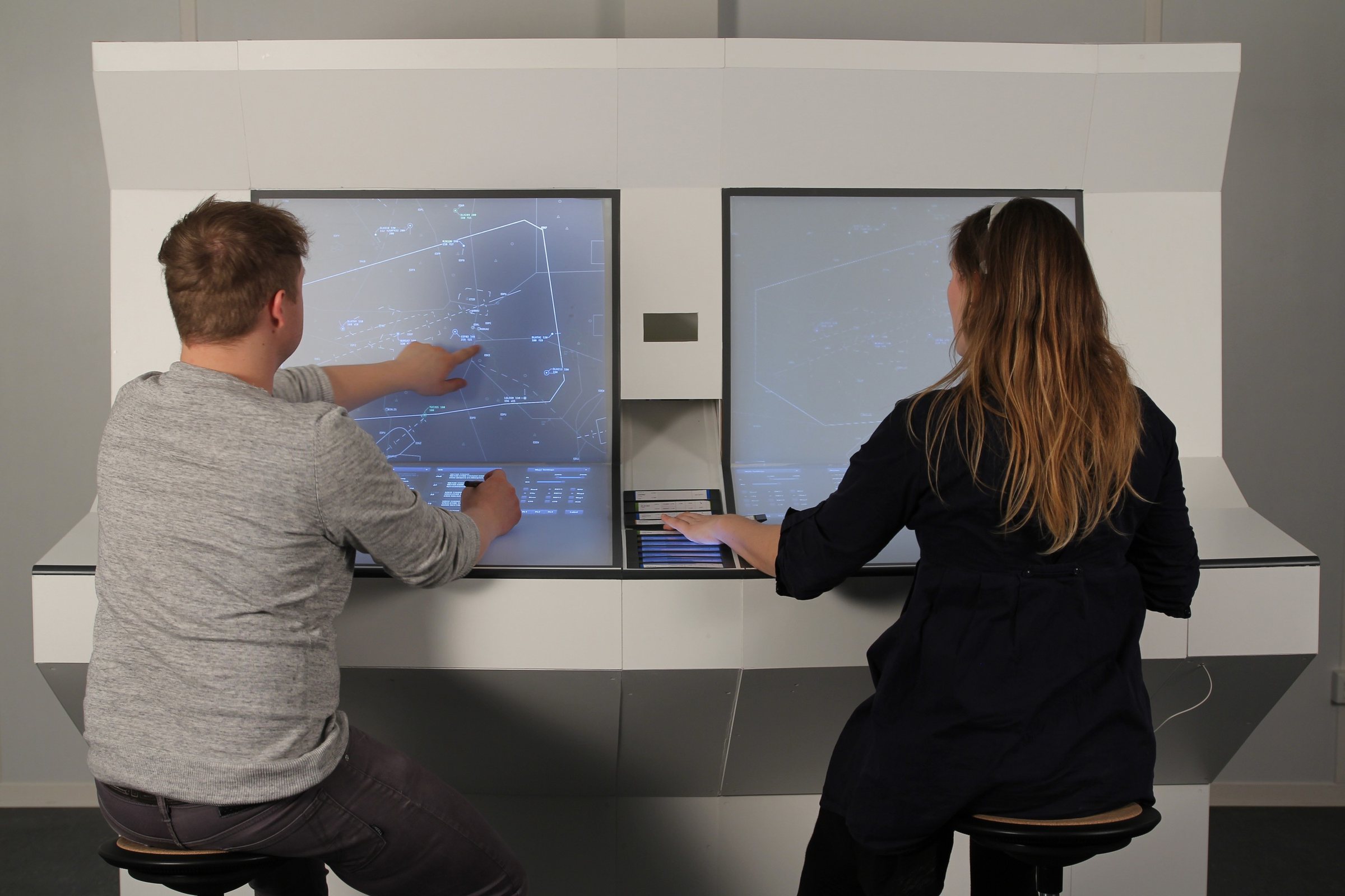 Two members of the TESS team exploring the full-scale air traffic control workstation model